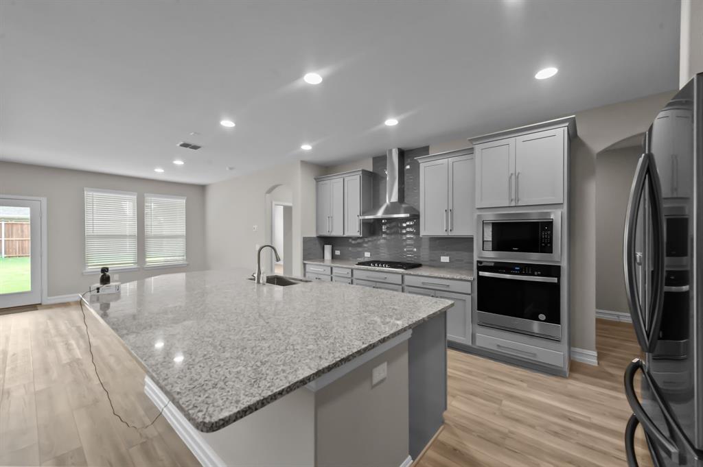 a kitchen with stainless steel appliances granite countertop a sink a stove and a microwave