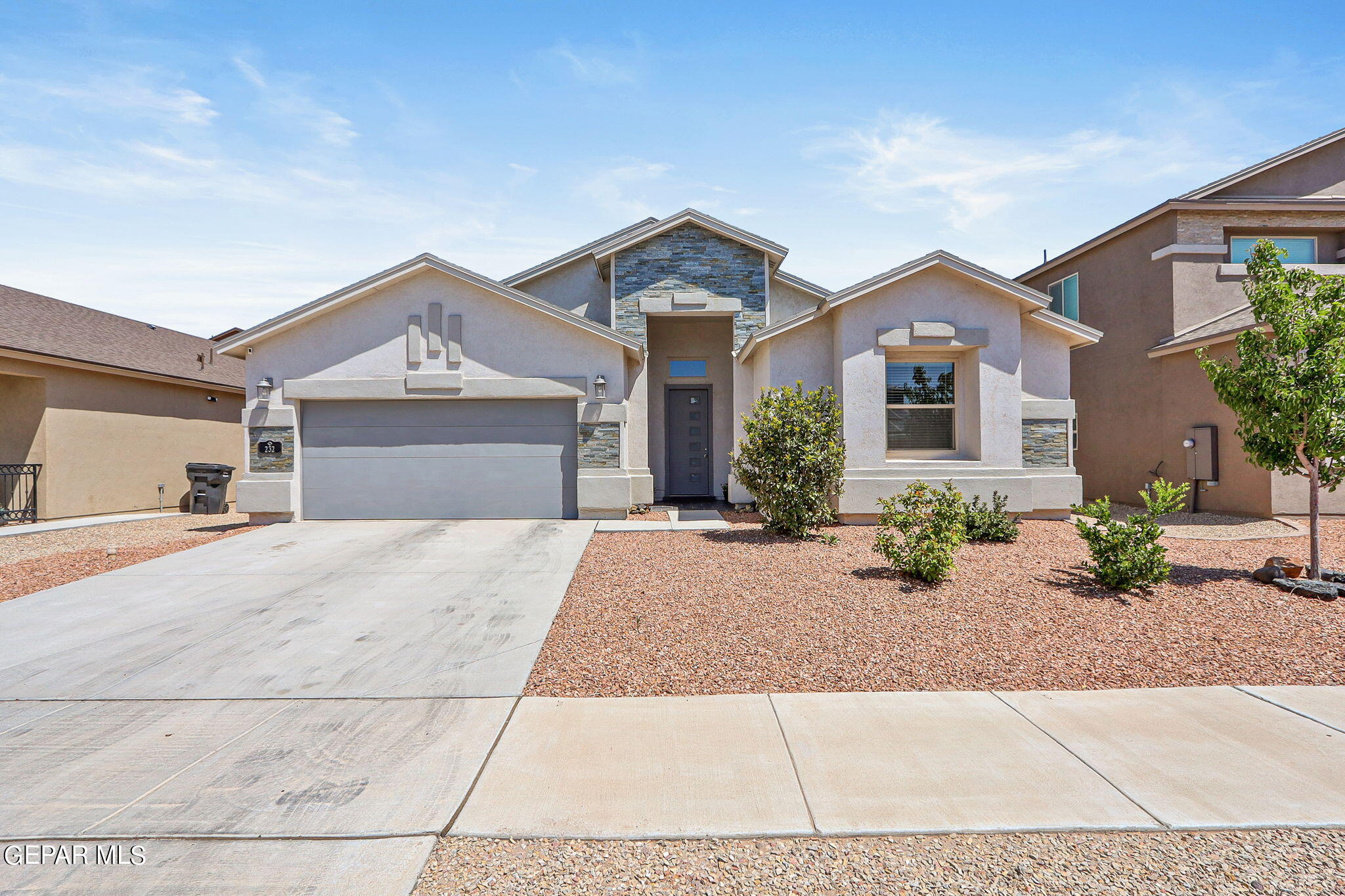 a front view of a house with a yard and a garage