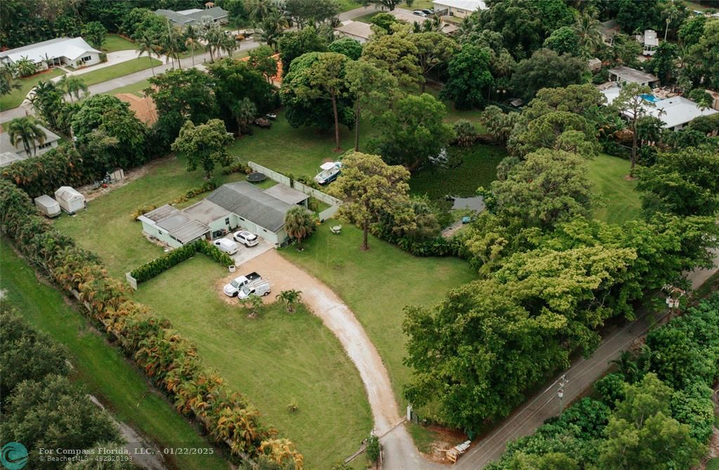 an aerial view of a house with a yard lake lake and residential houses with outdoor seating