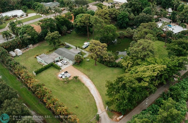 an aerial view of a house with a yard lake lake and residential houses with outdoor seating