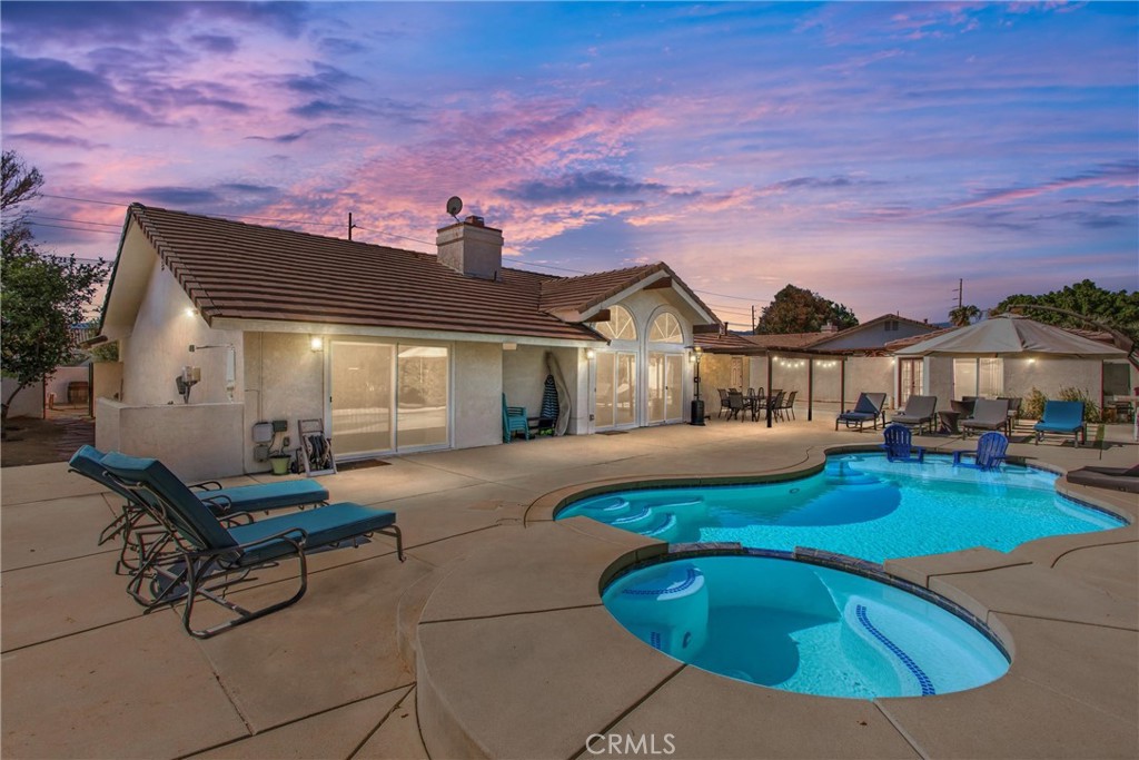 a front view of a house with swimming pool and sitting area