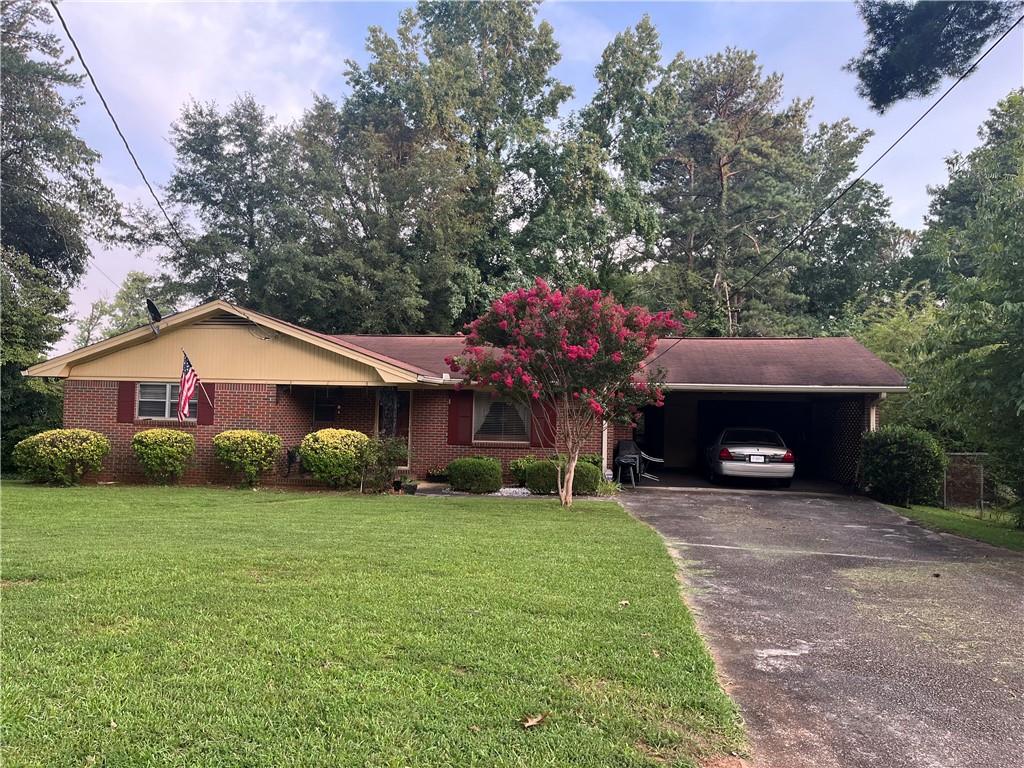 a view of a house with a yard and a large tree