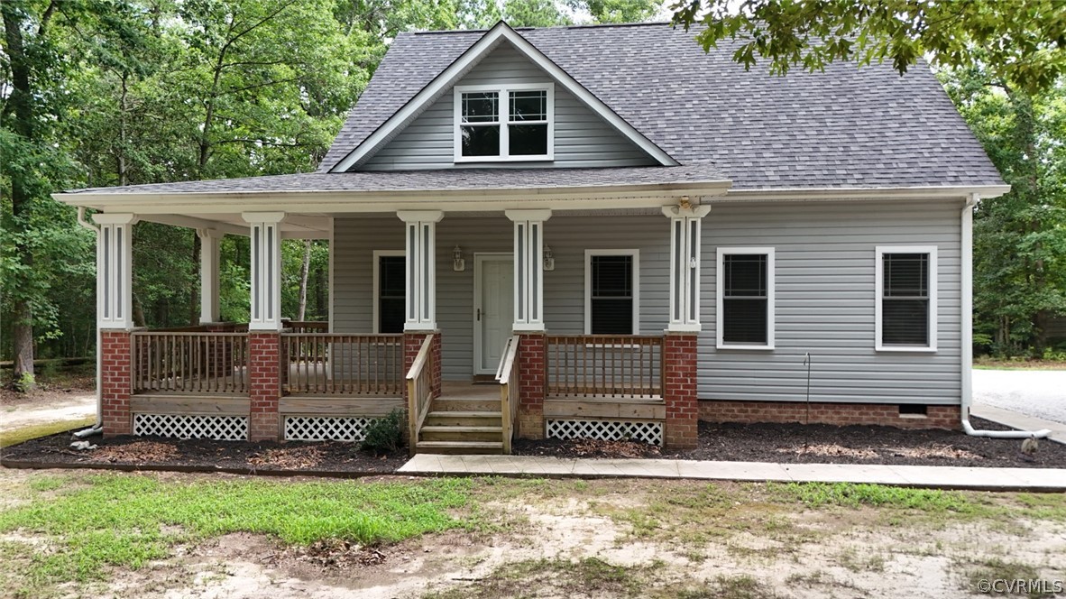 a view of a house with a small yard and a large tree