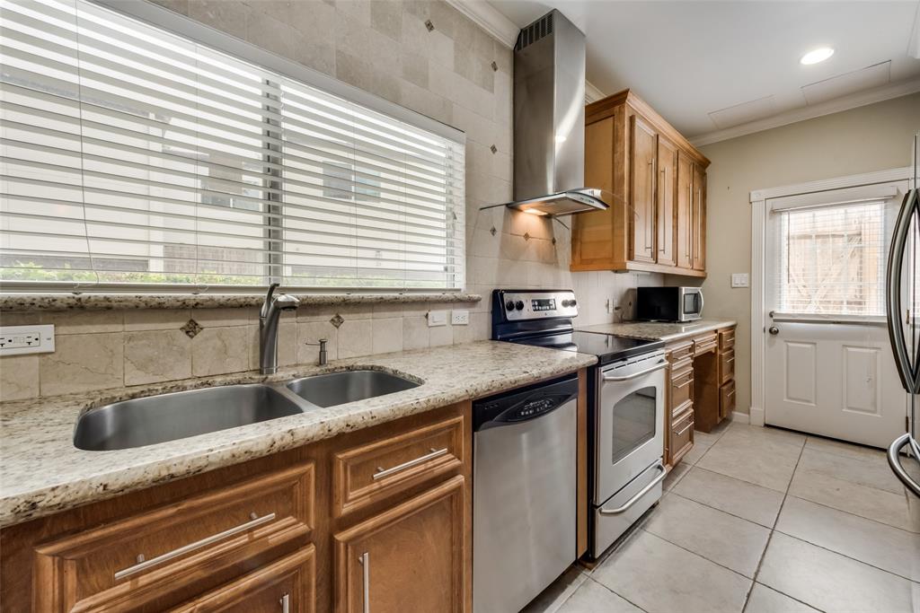 a kitchen with stainless steel appliances granite countertop a sink and a stove