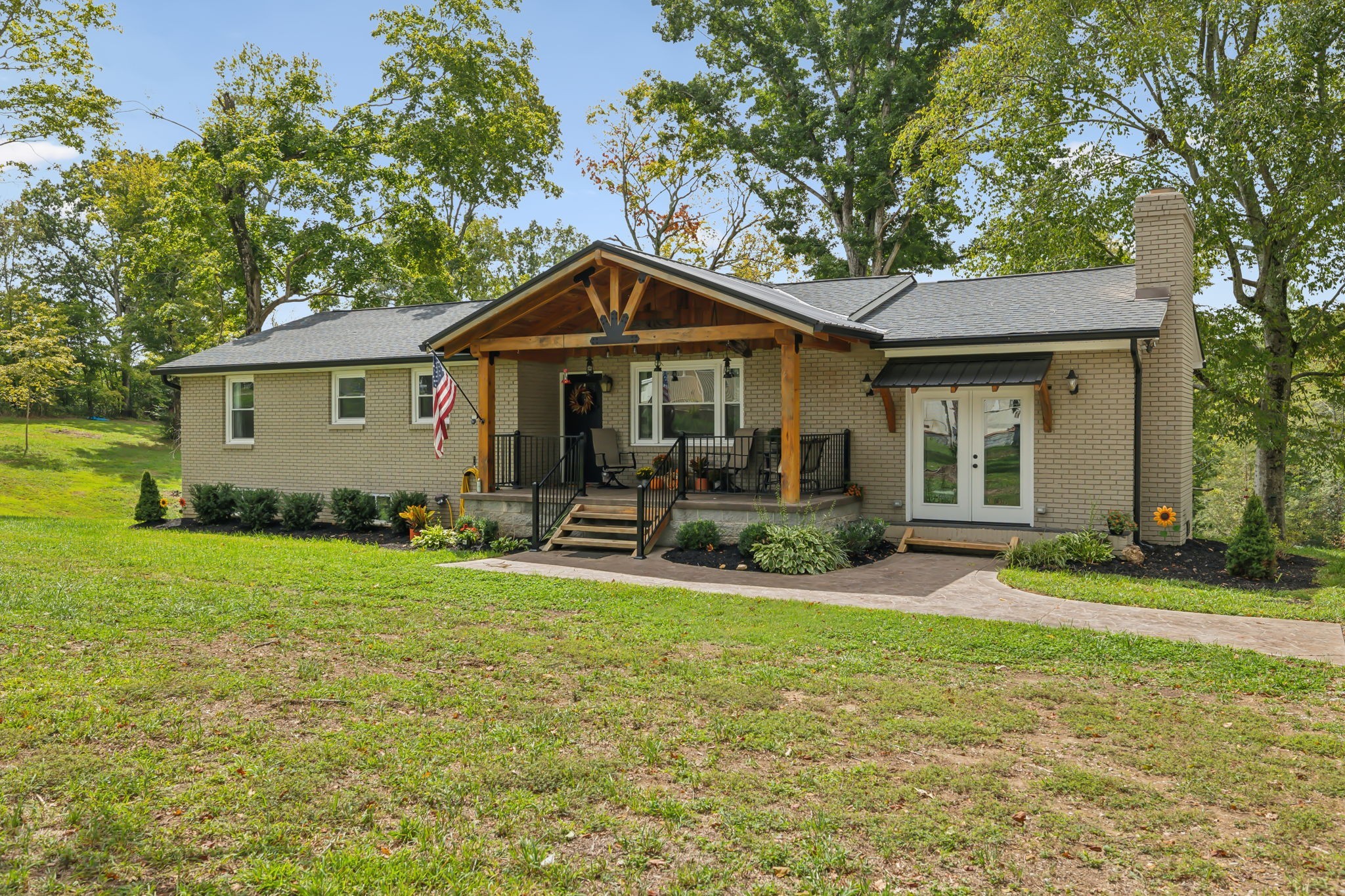 a front view of a house with a yard and trees