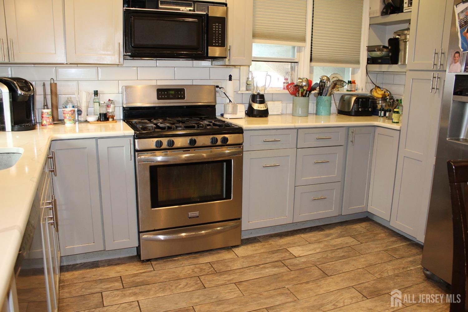 a kitchen with granite countertop a stove a sink and a microwave