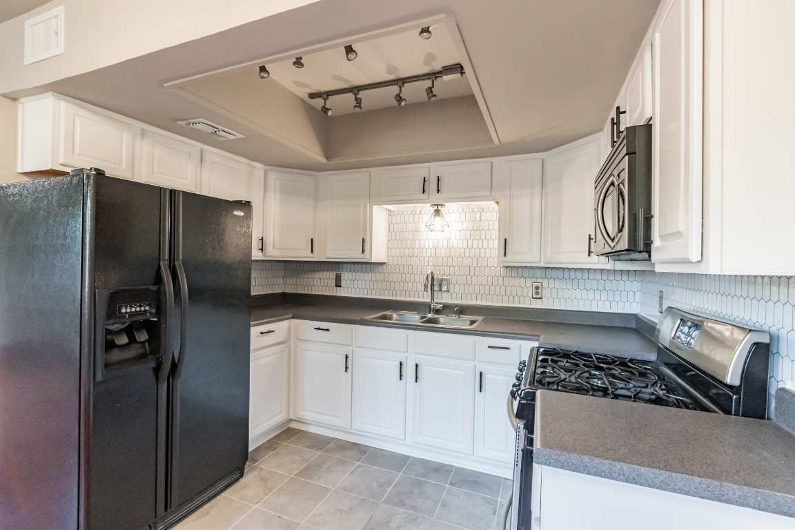 a kitchen with stainless steel appliances granite countertop a refrigerator and a sink