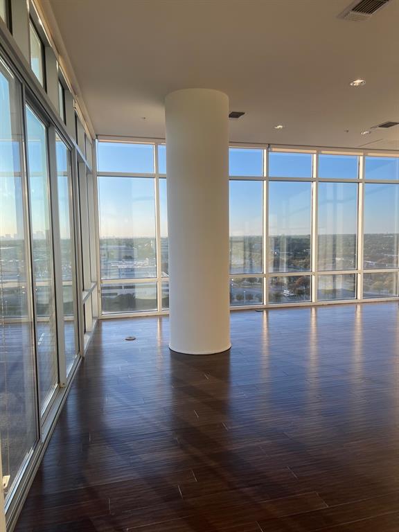 a view of room with wooden floor and floor to ceiling window