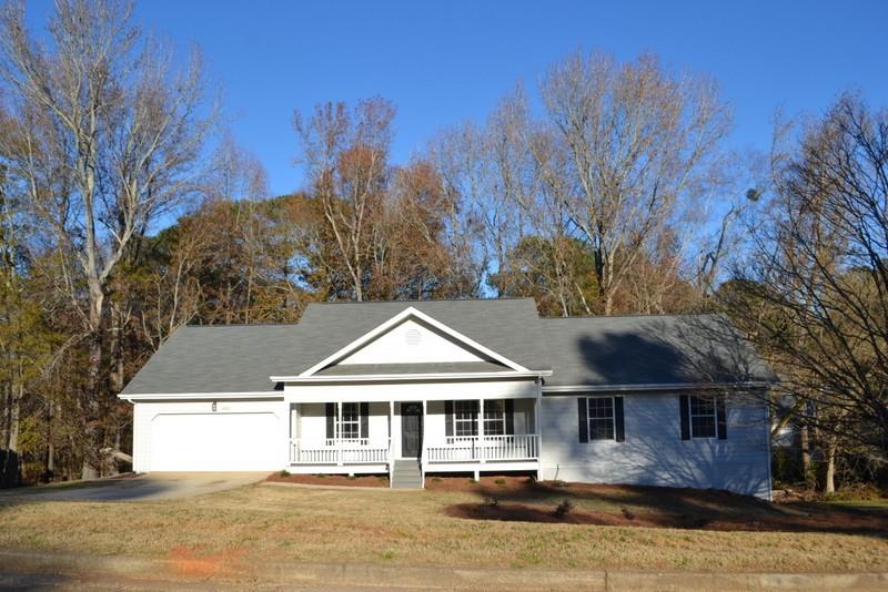 a front view of a house with a yard and lake view in back