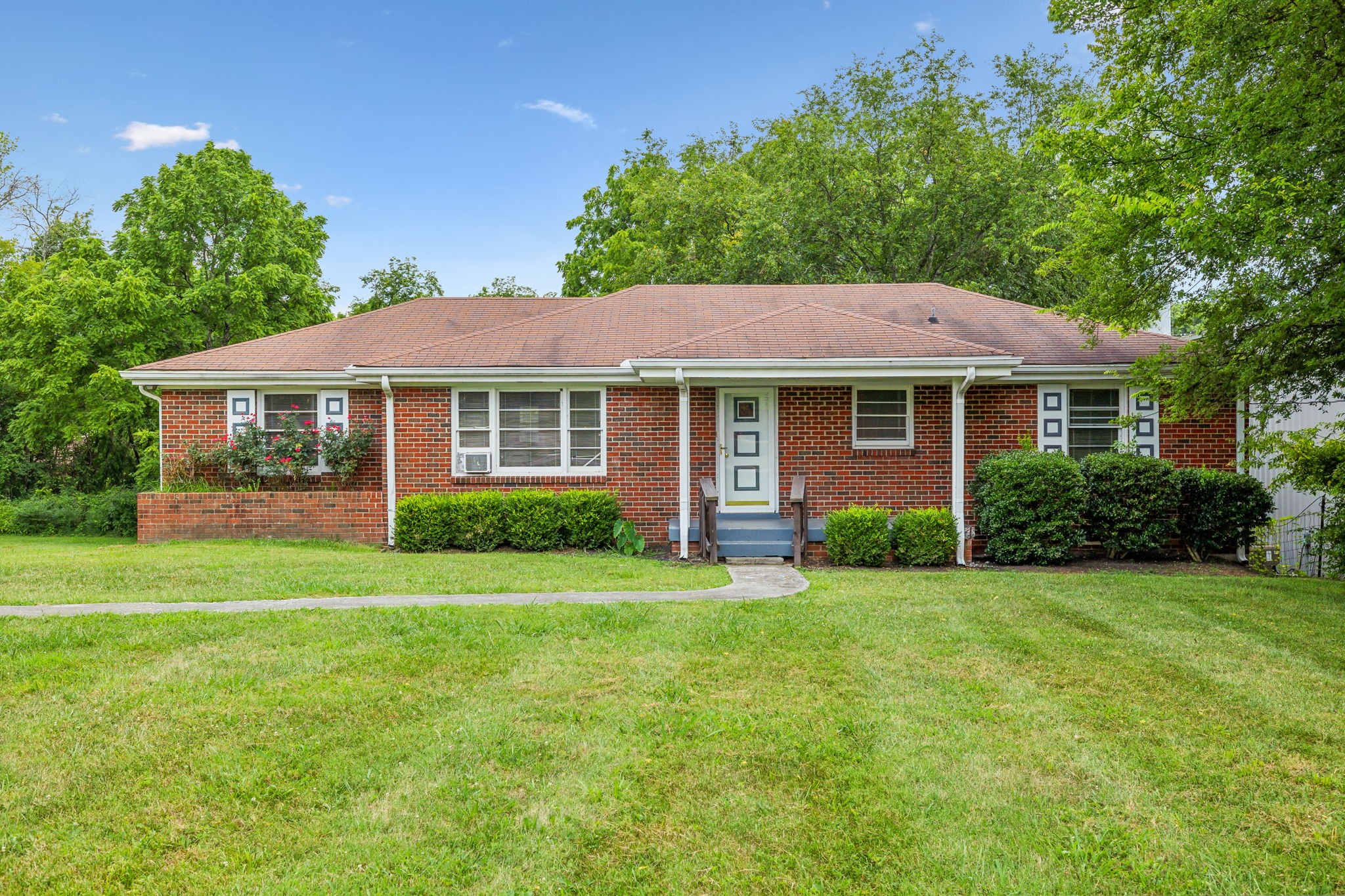 a front view of a house with a garden