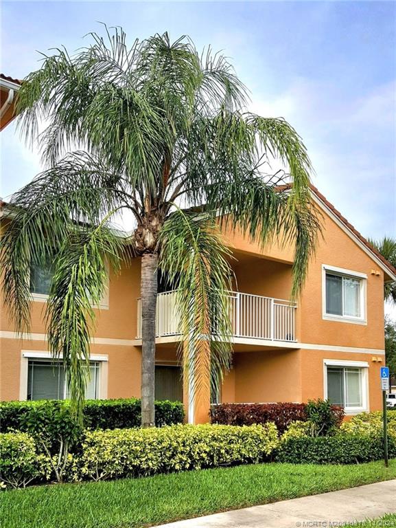 a front view of multi story residential apartment building with yard and green space