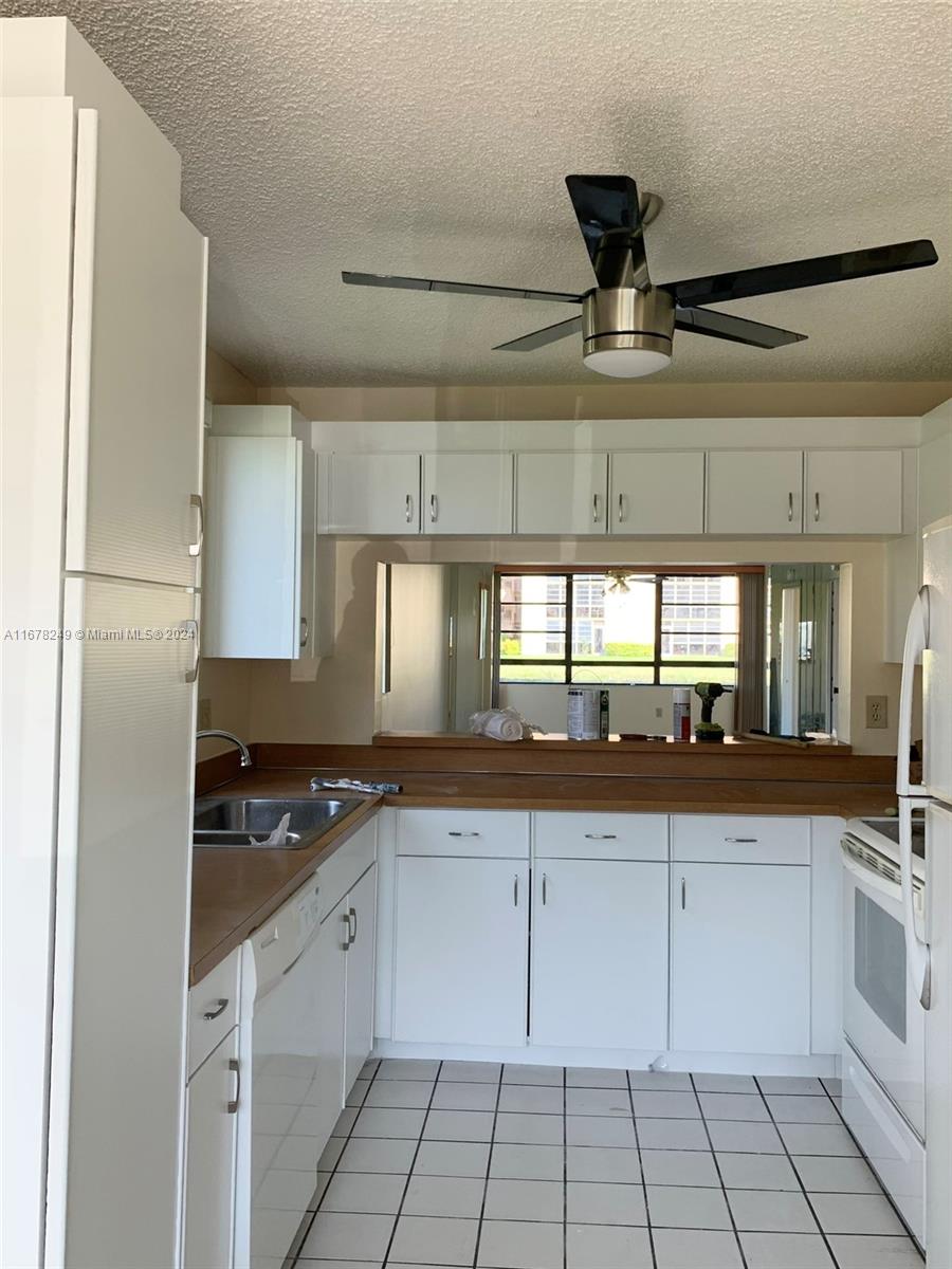 a kitchen with granite countertop a sink stainless steel appliances and cabinets