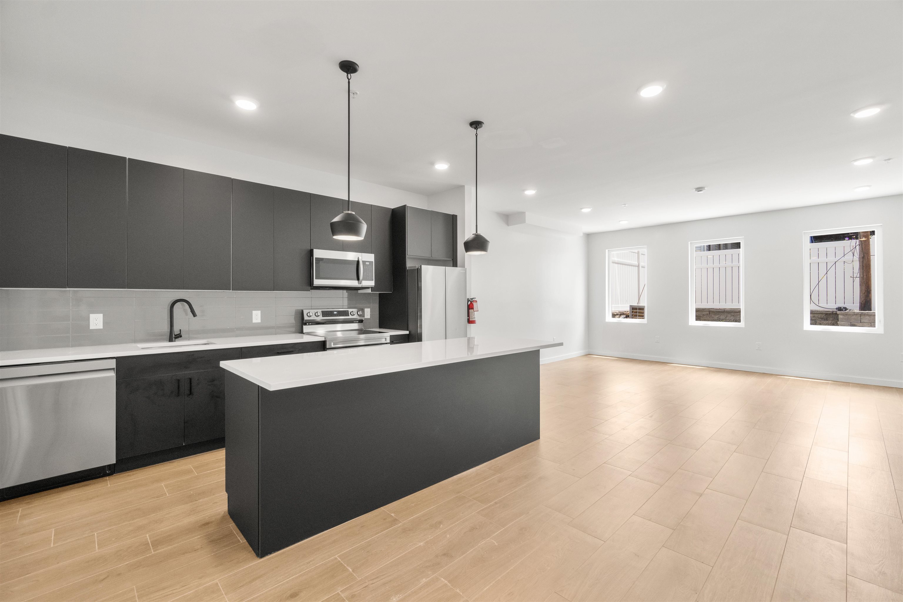 a large kitchen with kitchen island a sink stainless steel appliances and cabinets