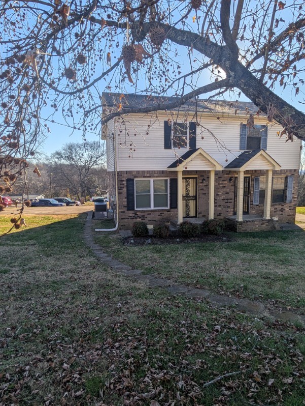 a view of a yard in front of a house with large trees