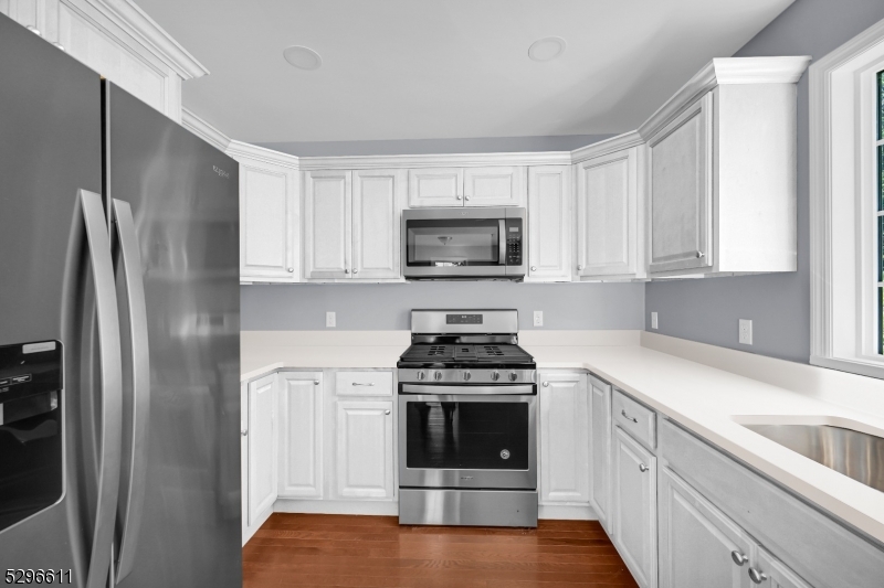 a kitchen with white cabinets and stainless steel appliances