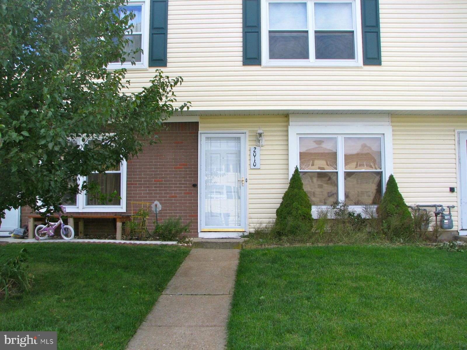 a front view of a house with a garden and plants