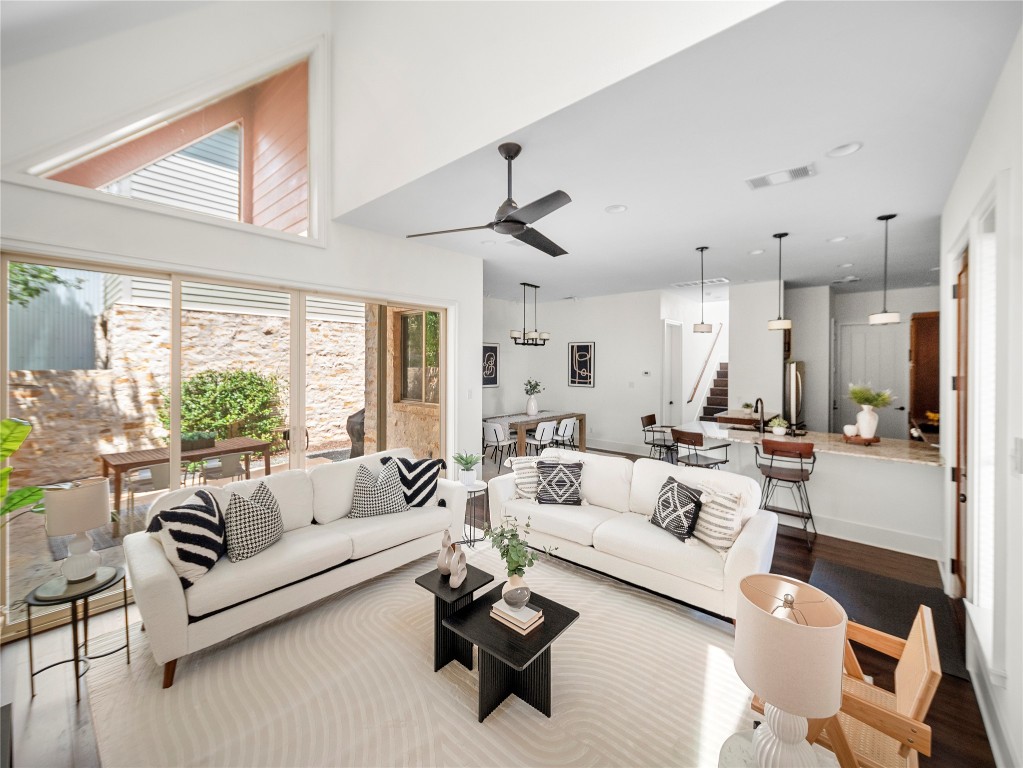 a living room with furniture white walls and a large window