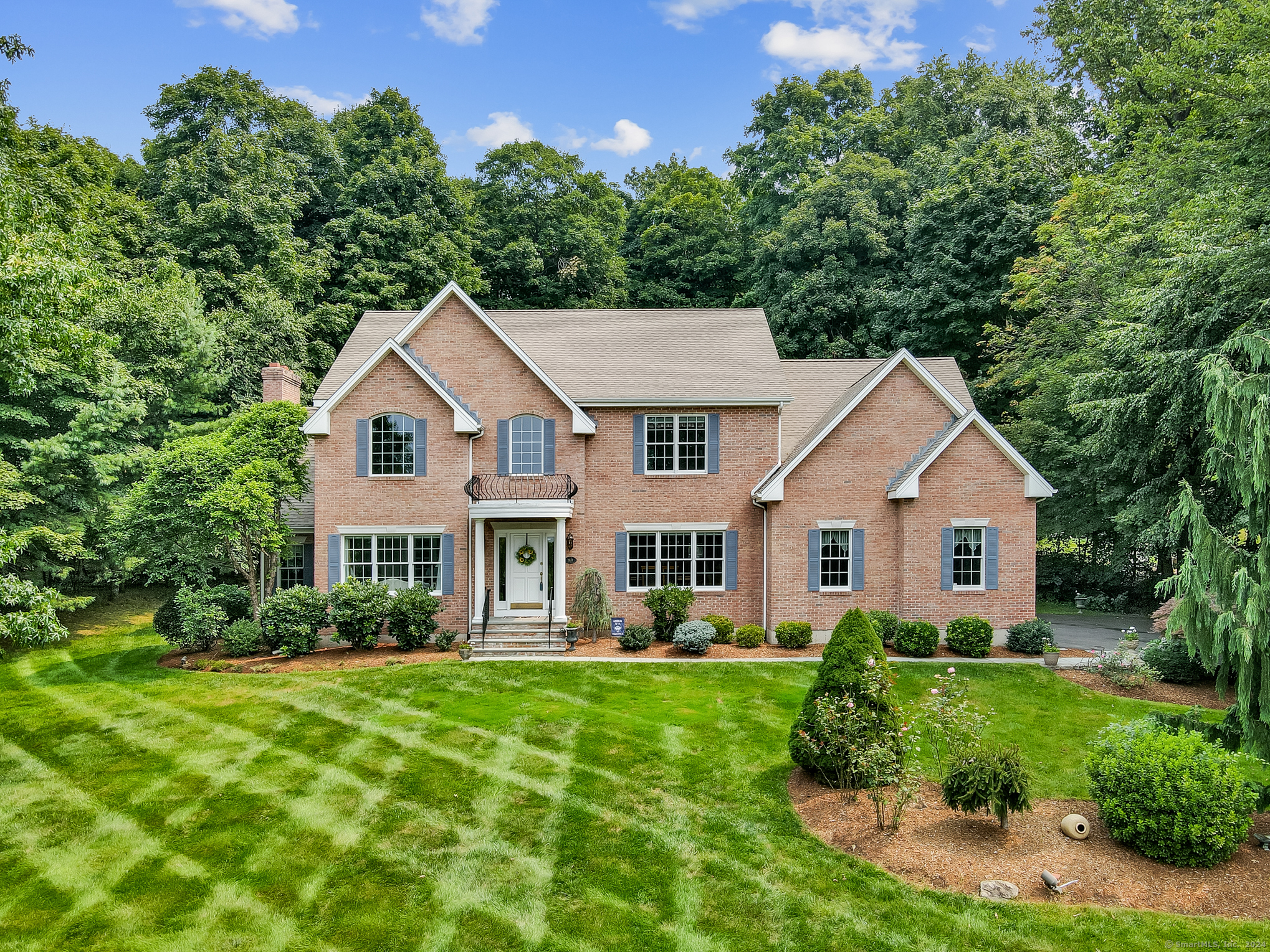 a front view of a house with a yard and green space