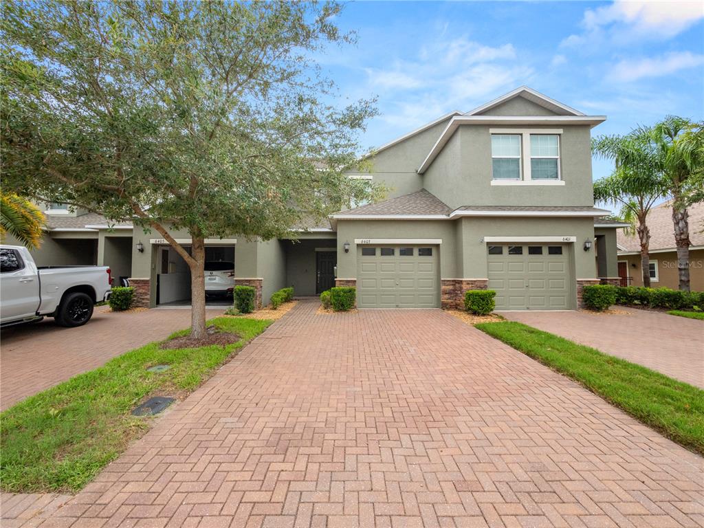 a front view of a house with a yard and a garage