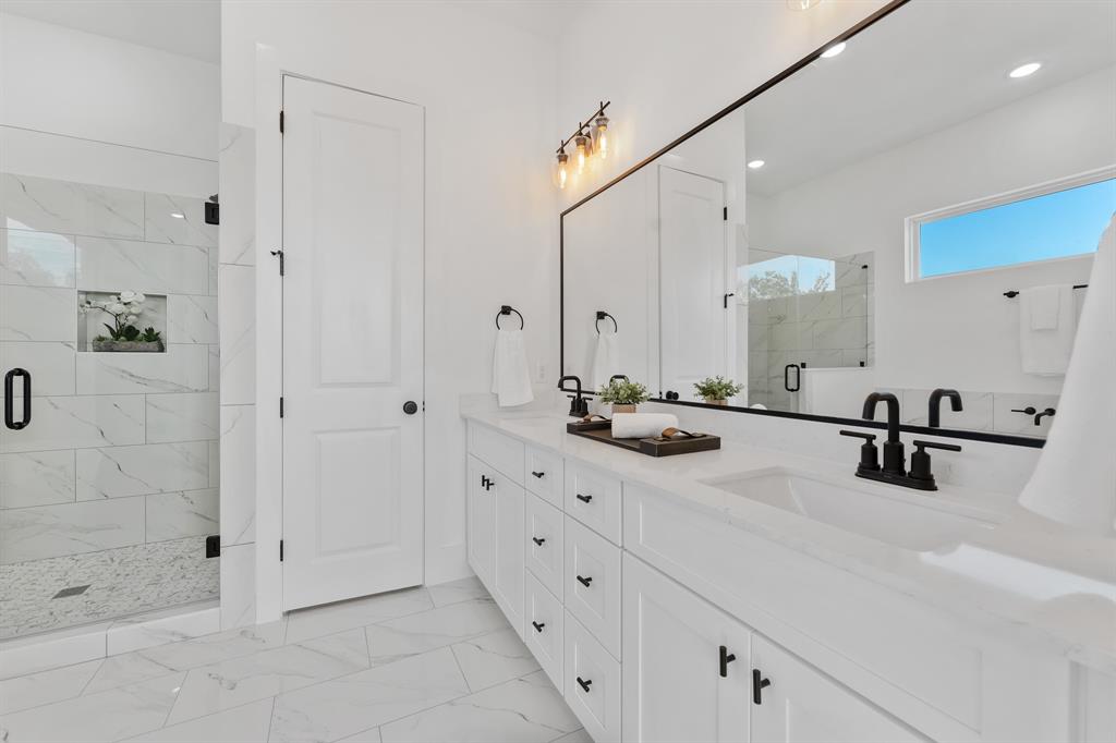 a bathroom with double vanity sink a mirror and shower