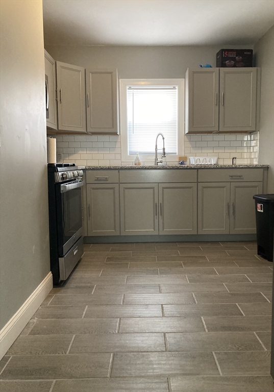 a kitchen with a sink a stove and cabinets