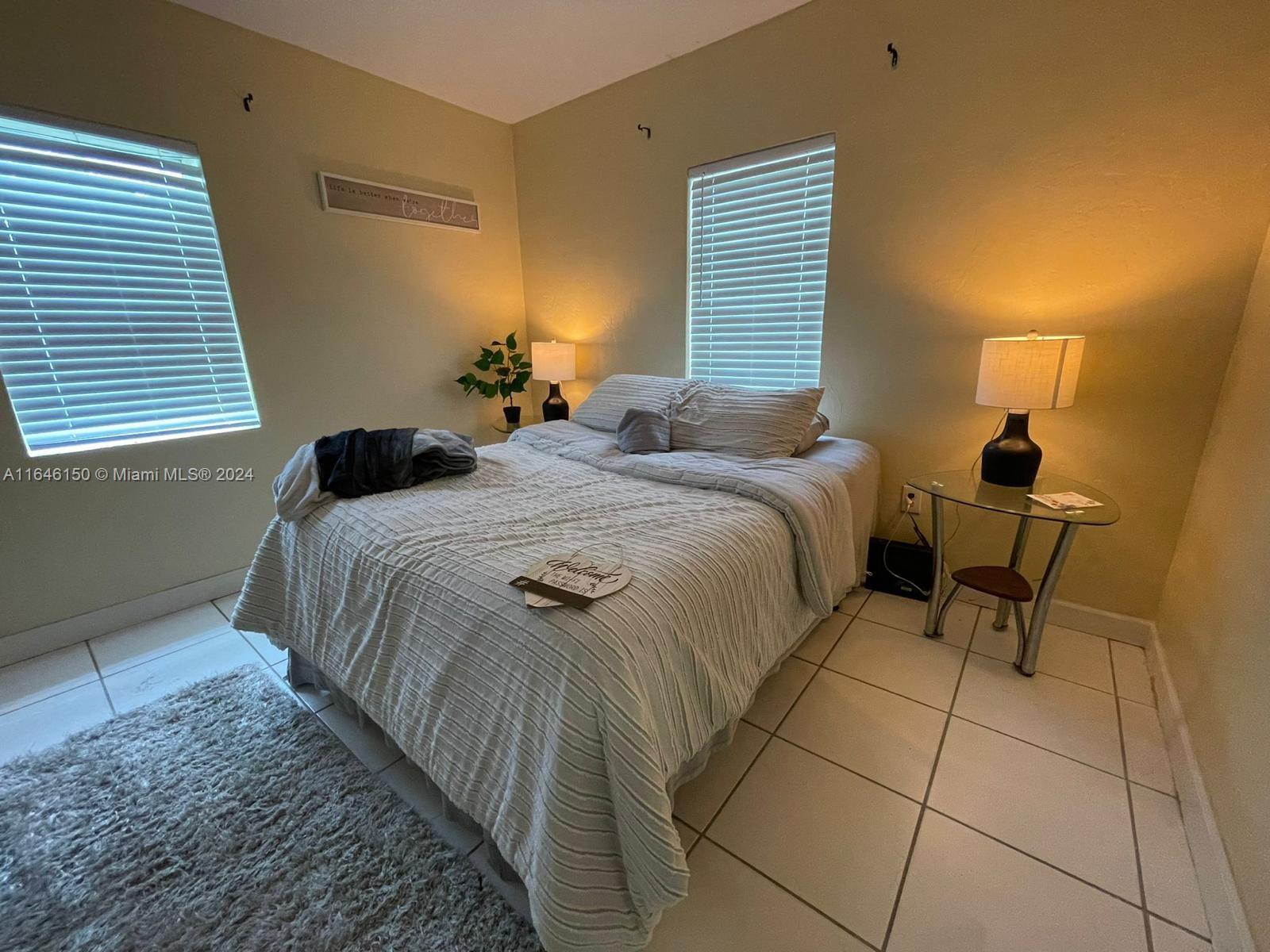 a bedroom with a bed and a lamp next to a window