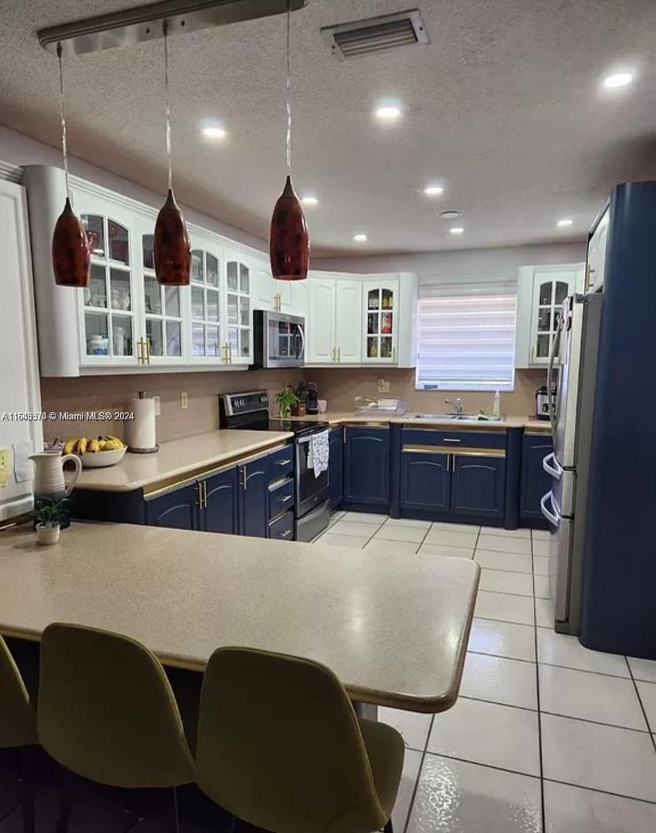 a kitchen with stainless steel appliances granite countertop a sink a stove and a refrigerator