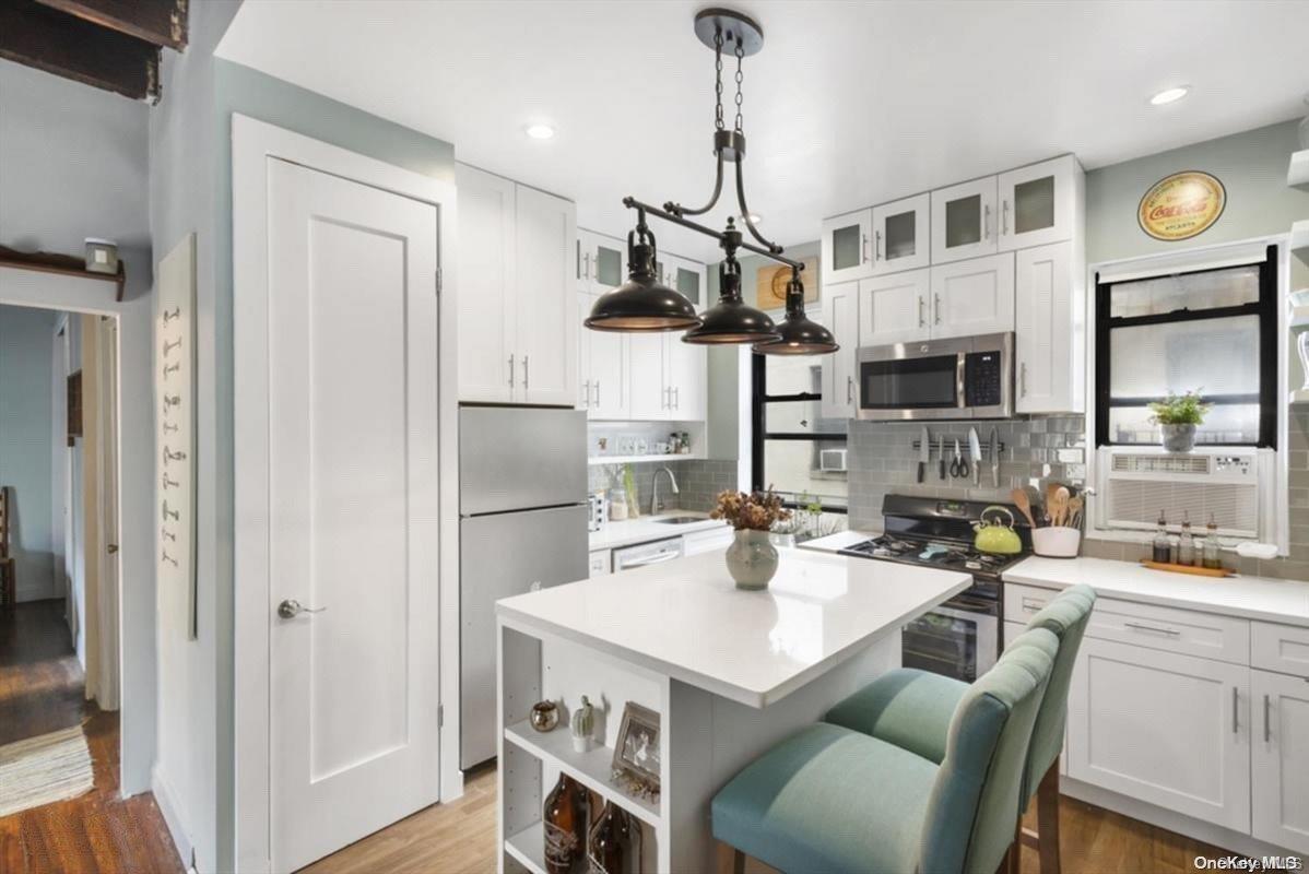 a kitchen with stainless steel appliances a stove a refrigerator and a view of living room