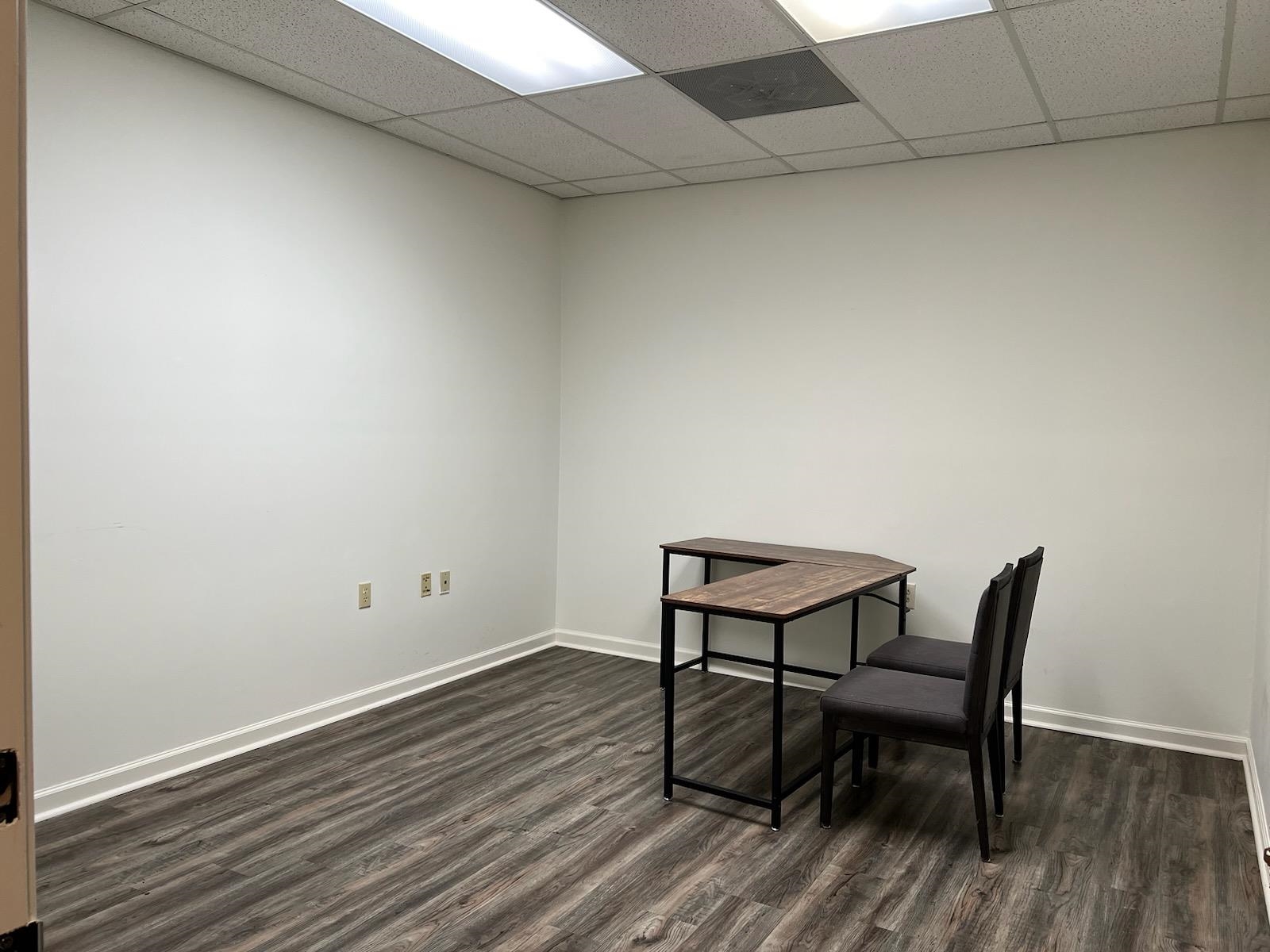 a view of a room with wooden floor and a window