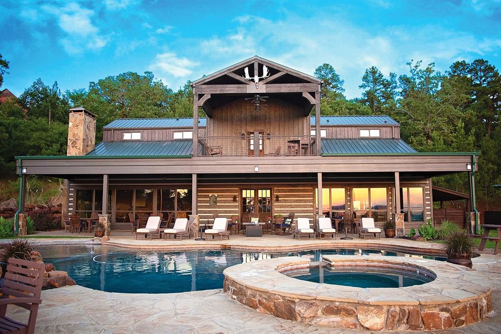 a front view of a house with swimming pool and furniture