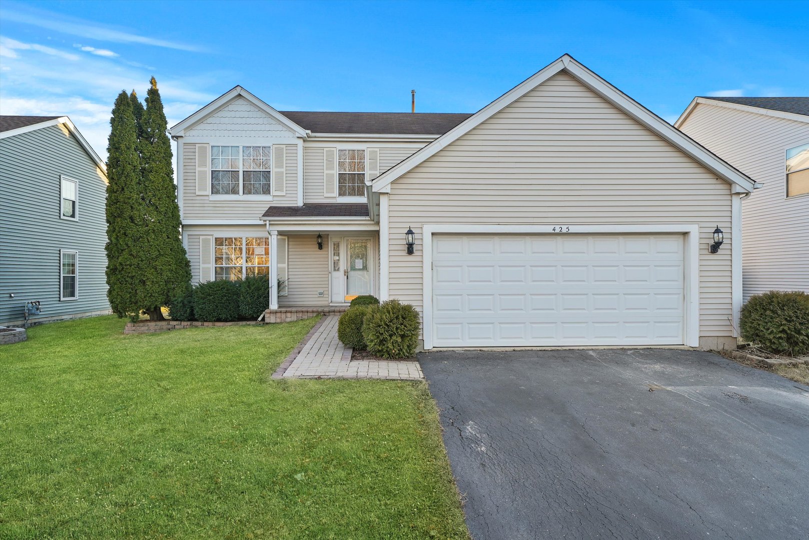 a front view of a house with a yard and garage