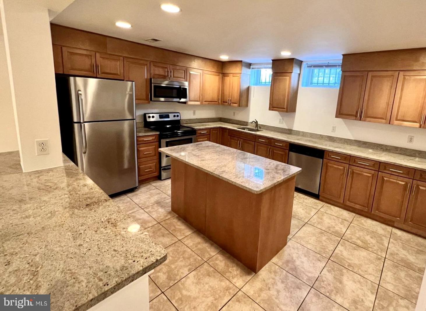 a kitchen with stainless steel appliances granite countertop a stove a refrigerator and a sink