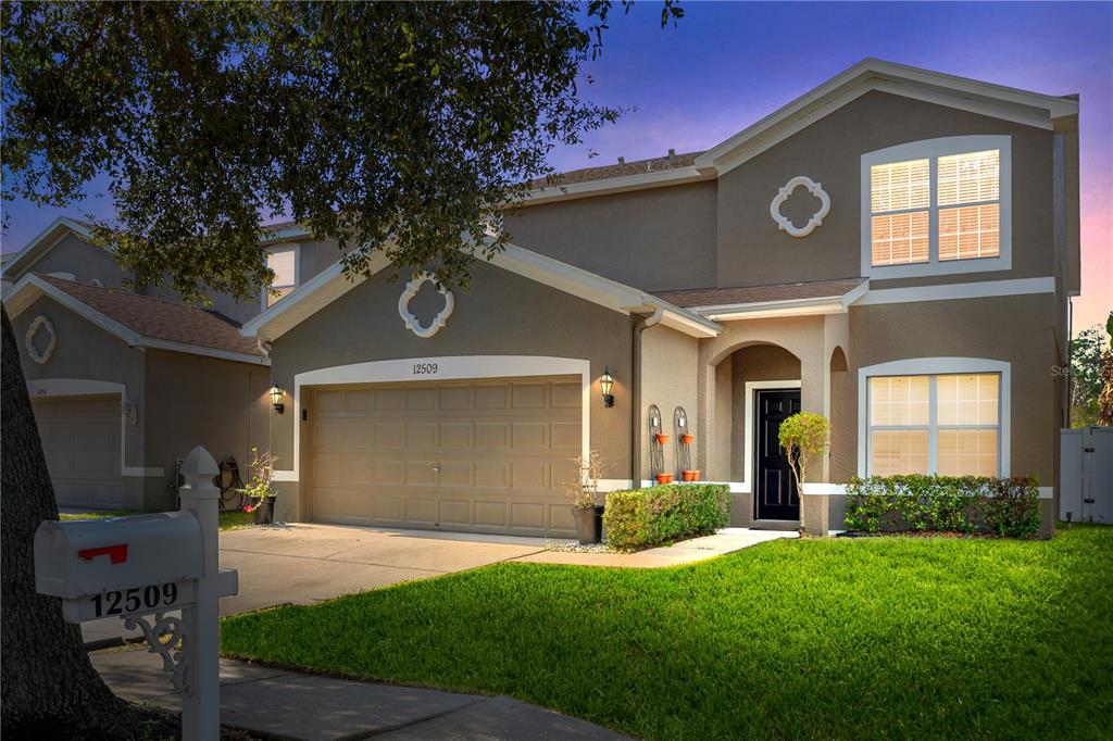 a front view of a house with a yard and garage