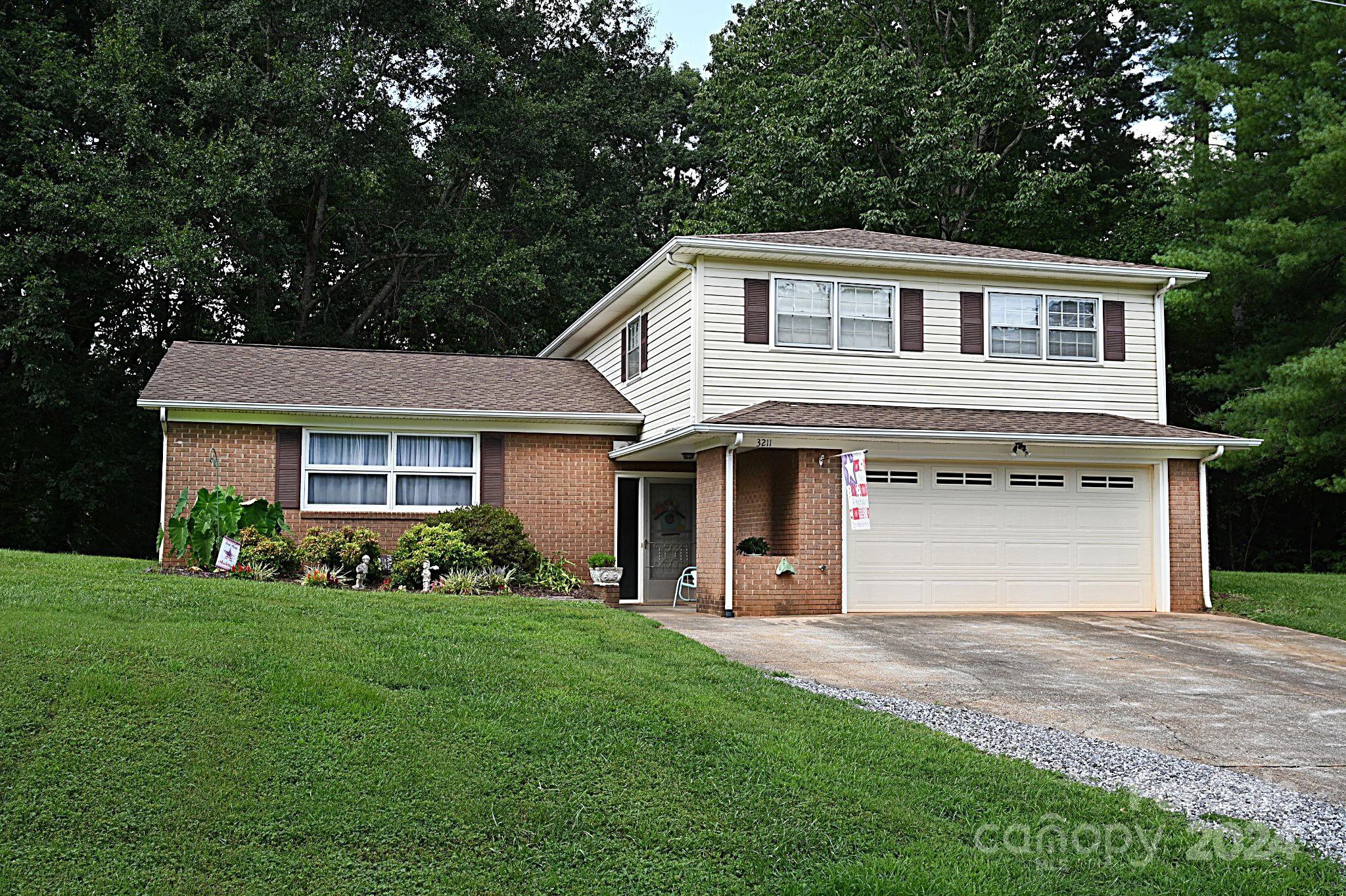 a front view of a house with a garden and yard