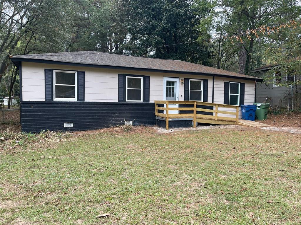 a front view of house with deck and yard