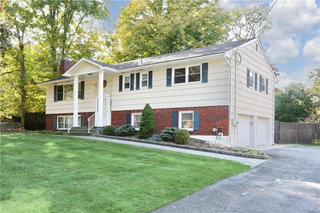 a front view of a house with a garden and yard