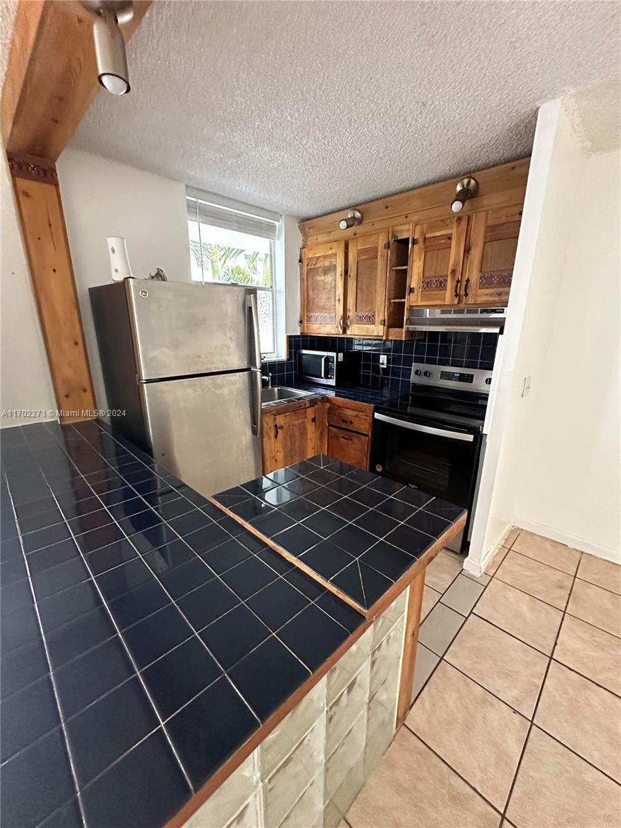 a kitchen with granite countertop a stove and a refrigerator