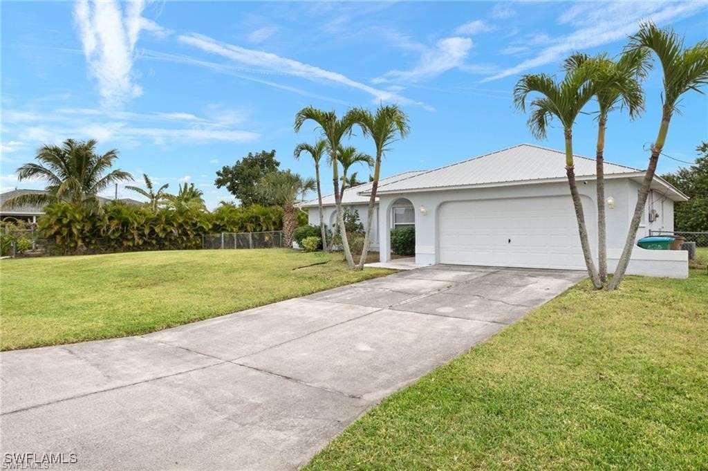 a view of a house with a yard and palm trees