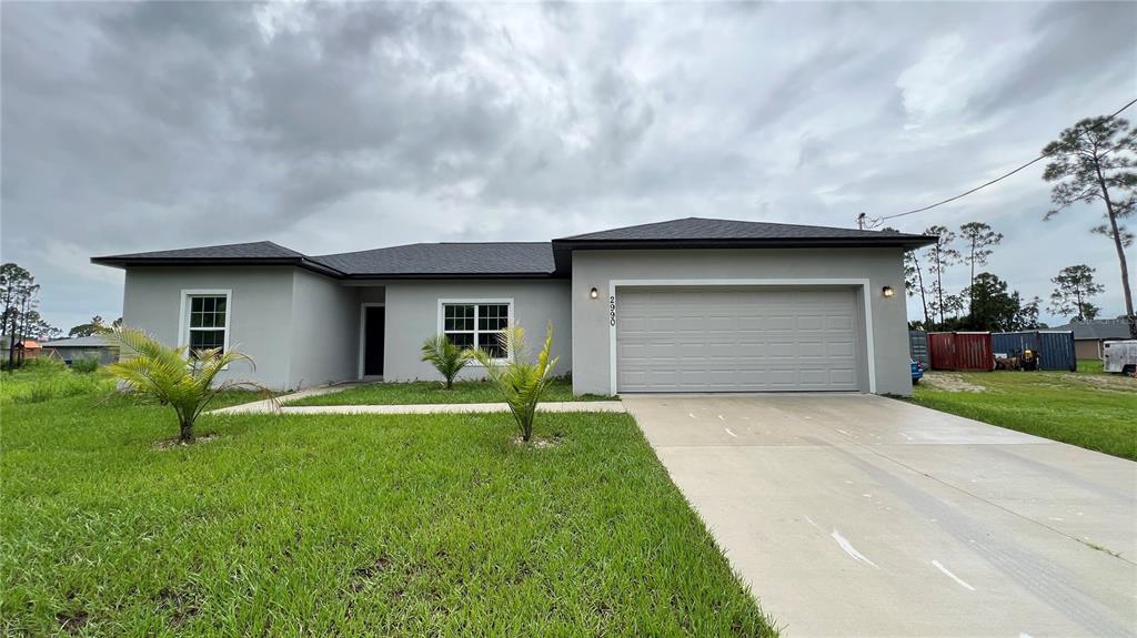 a front view of a house with a yard and garage