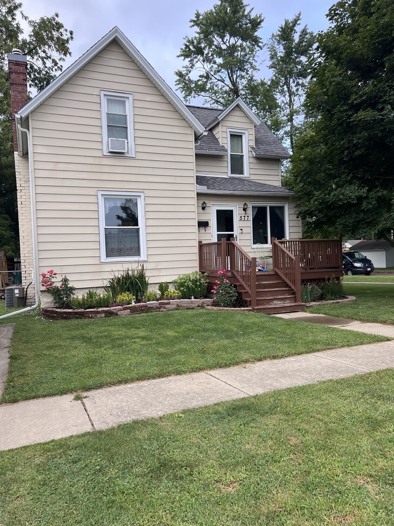 a front view of a house with a garden and yard