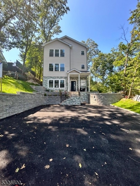 a front view of a house with a yard and lake view