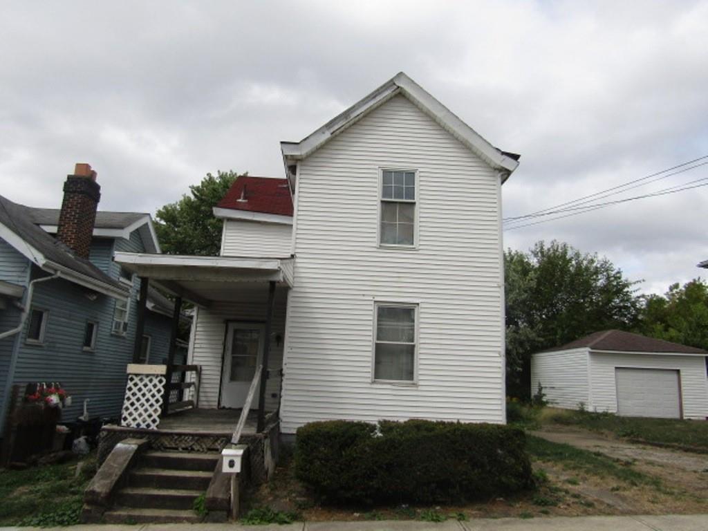 a front view of a house with plants