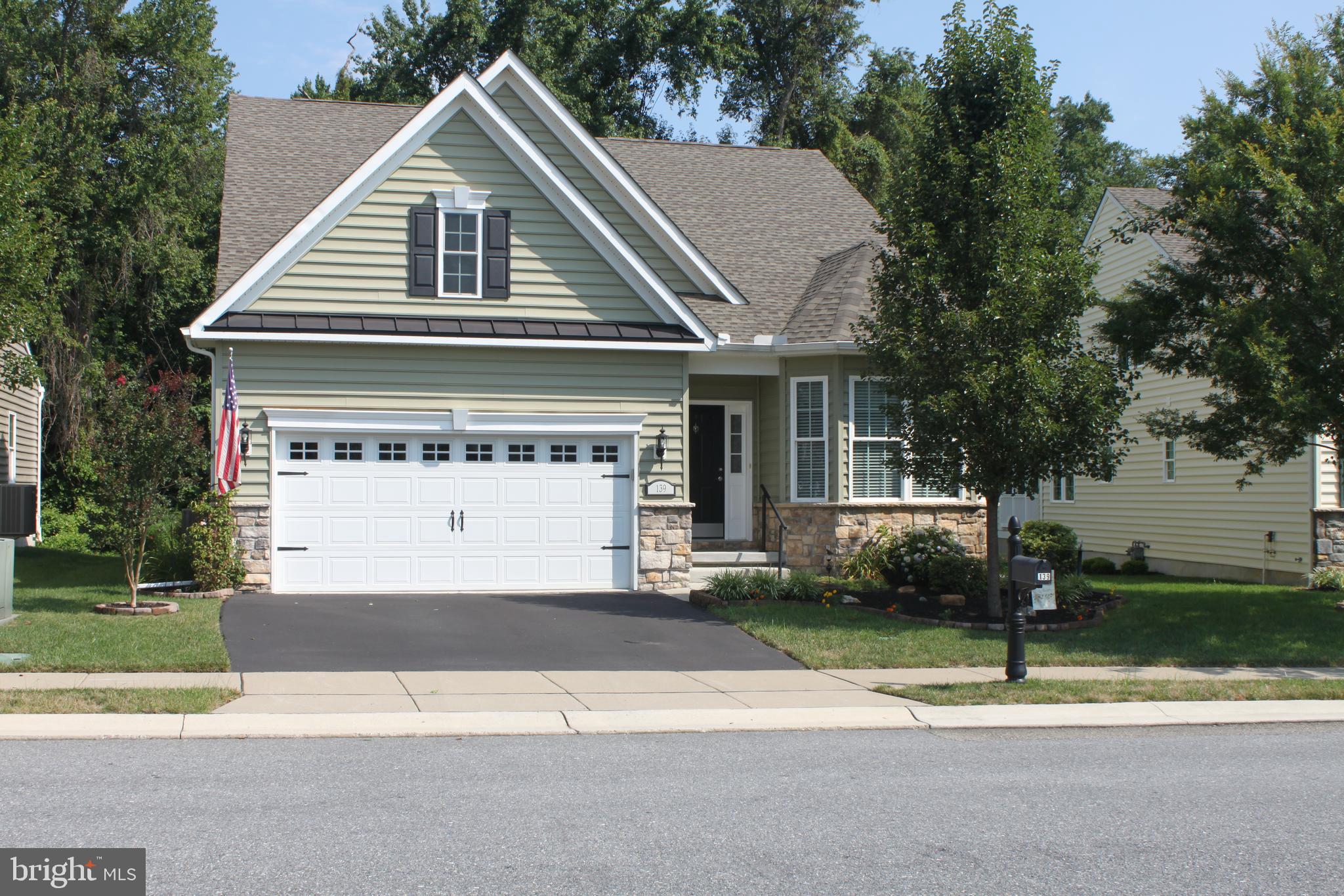 a view of a house with a yard and large tree