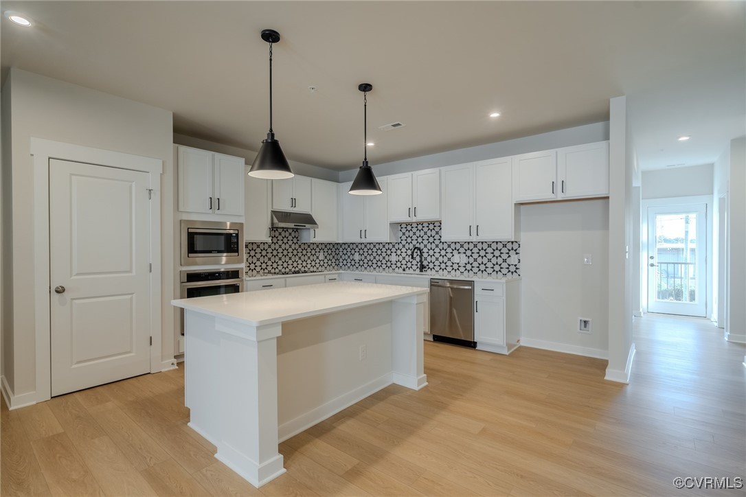 a kitchen with stainless steel appliances granite countertop a stove a sink and a refrigerator