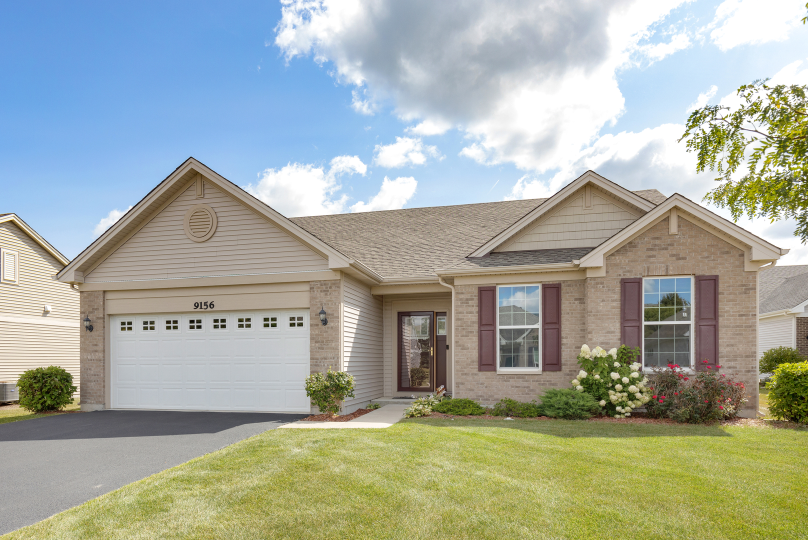 a front view of a house with a yard and garage