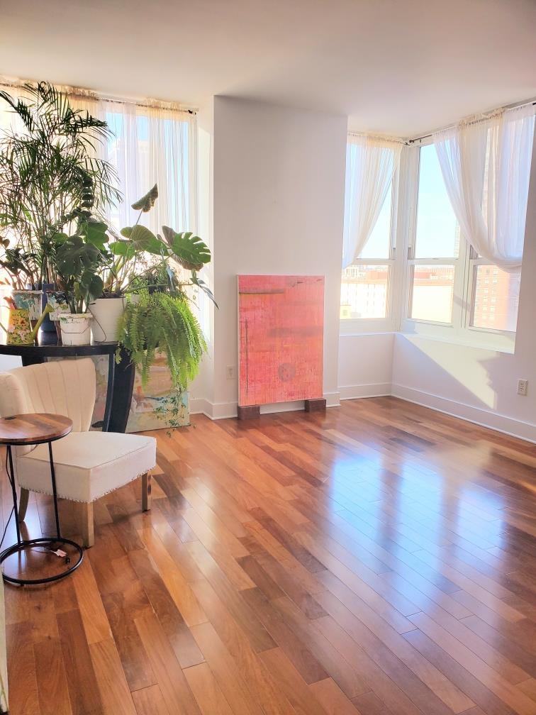 a view of a room with wooden floor and windows