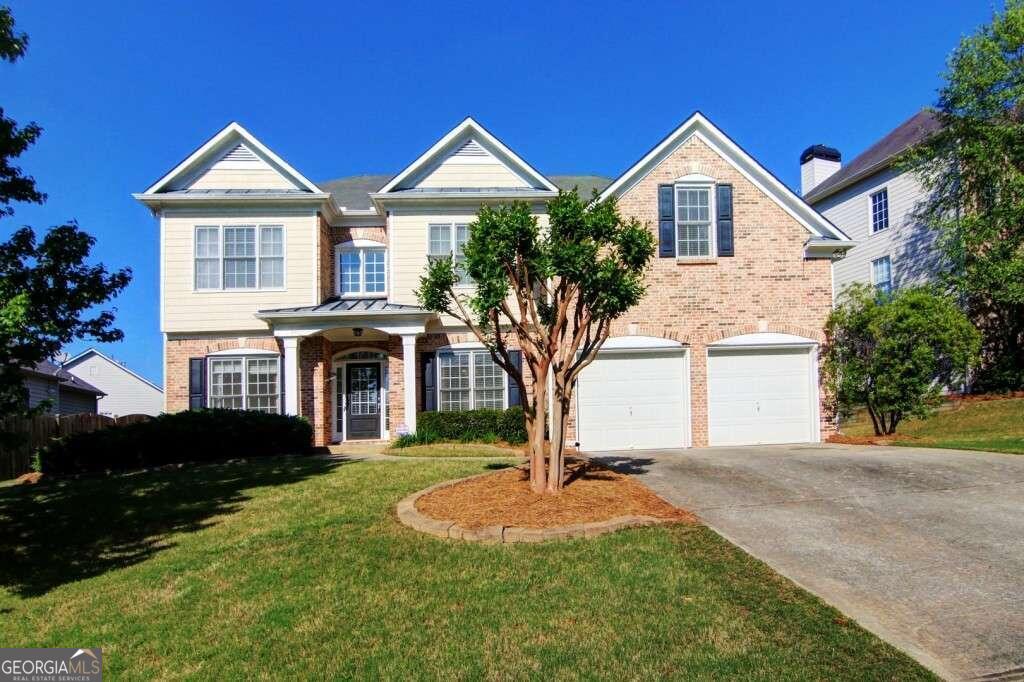 a front view of a house with a yard and garage