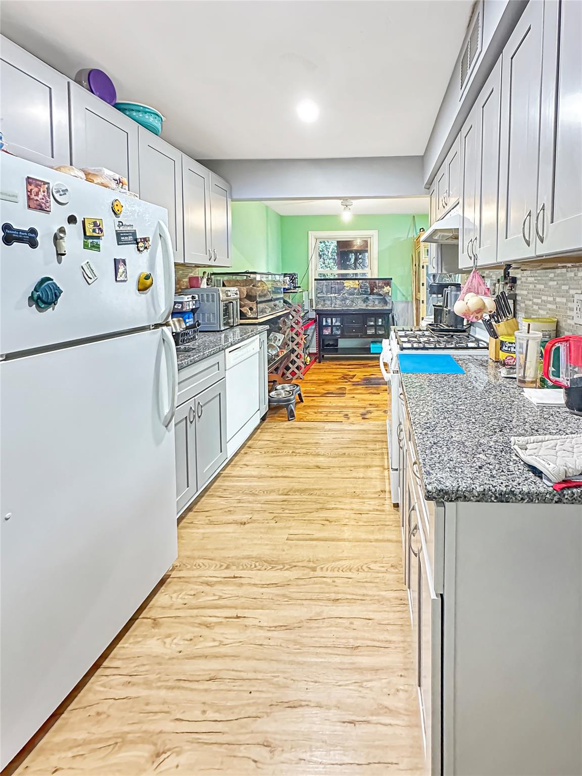 a kitchen with stainless steel appliances granite countertop a refrigerator sink stove and cabinets