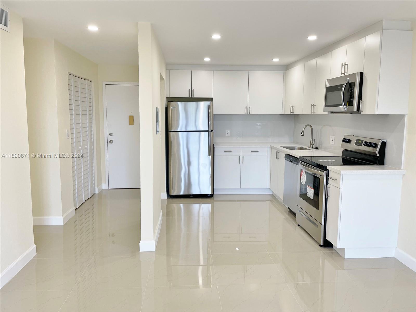 a kitchen with stainless steel appliances granite countertop a refrigerator and a stove top oven