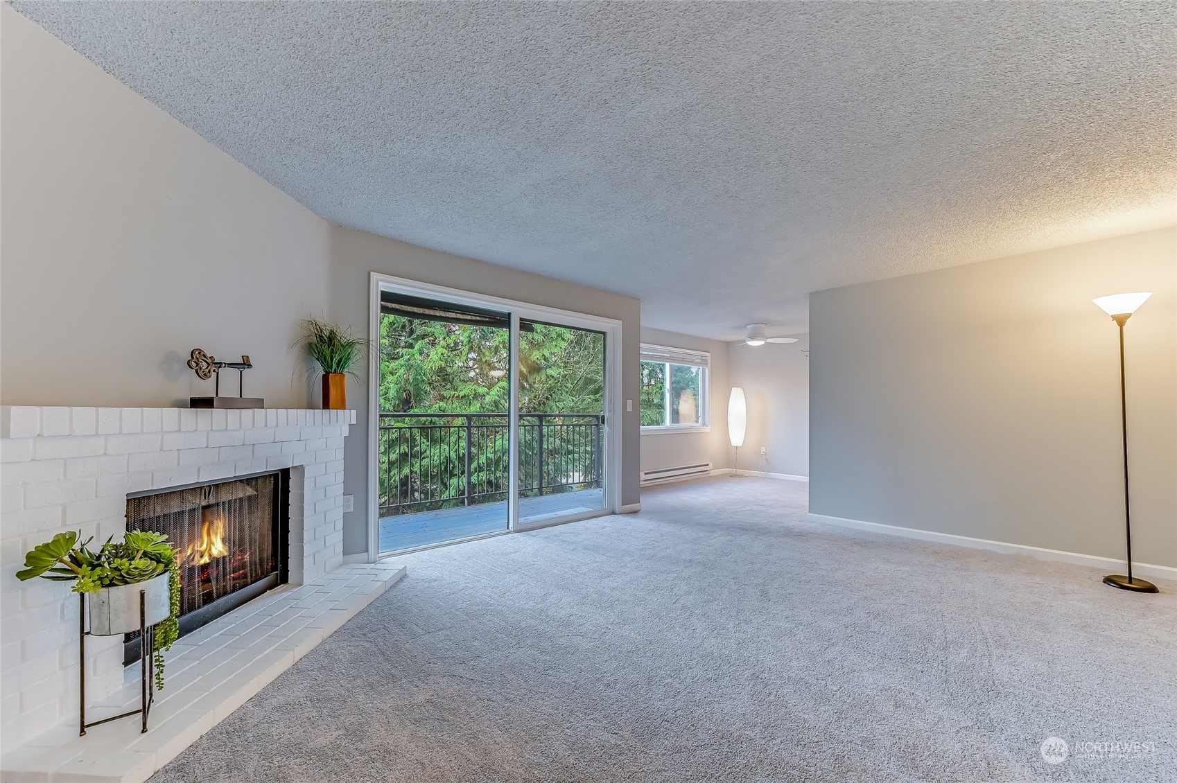 a view of an empty room with a fireplace and a window